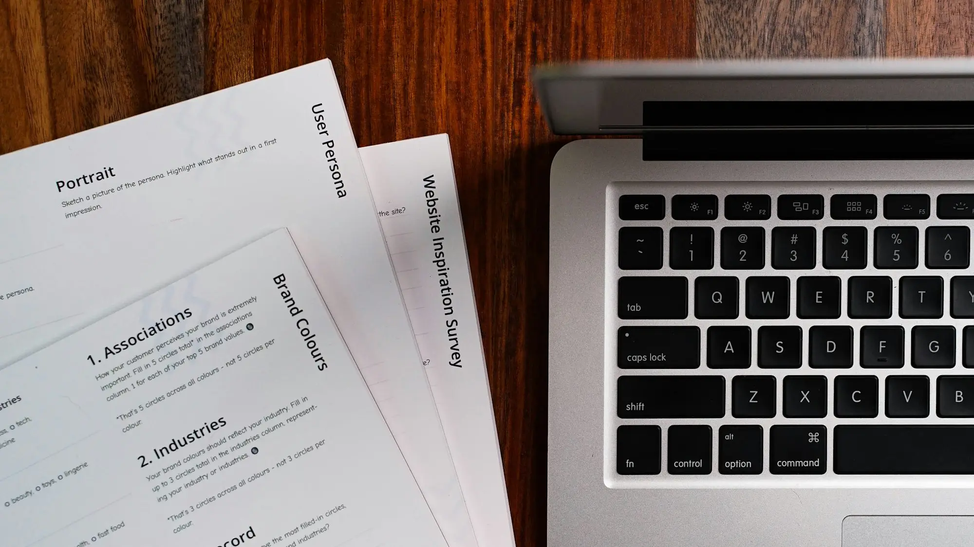 Laptop and documents on a wooden table
